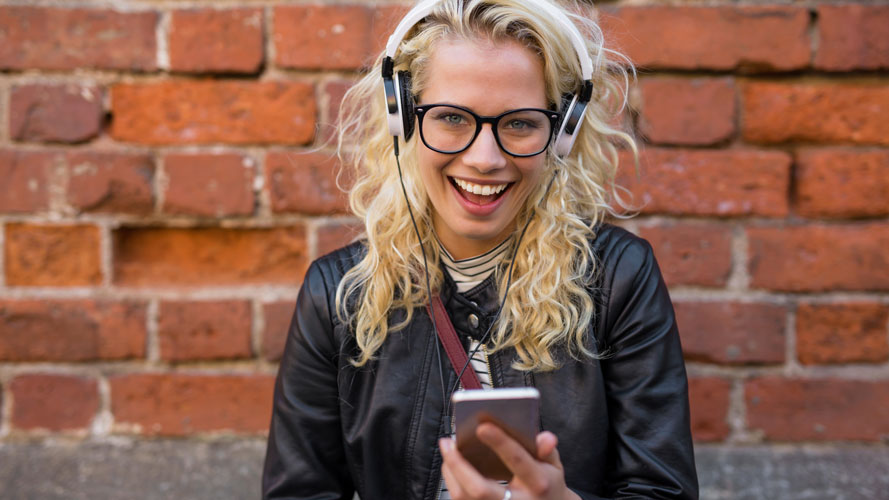 Female student smiling holding mobile device