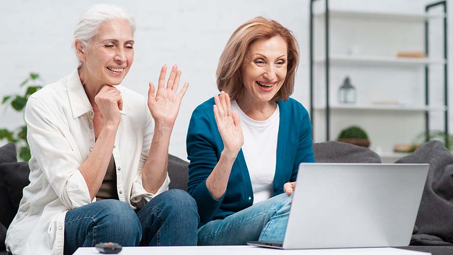 Friends watching a GuideConnect demonstration on a laptop.